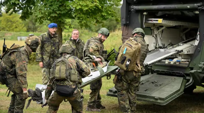 Bundeswehr ruošiasi masinei evakuacijai: 1000 sužeistųjų per dieną NATO-Rusijos konflikte Bundeswehr medicinos pratybos: kariai evakuuoja sužeistąjį simuliacijoje, remiantis Ukrainos karo pamokomis
